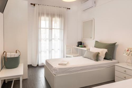biała sypialnia z łóżkiem i oknem w obiekcie Hotel Theopisti w mieście Uranupoli