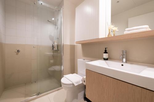 a bathroom with a sink and a toilet and a shower at Brand New 2br2ba Caulfield Parkbalcony Poolgym in Melbourne