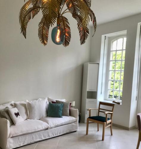 - un salon avec un canapé et un palmier dans l'établissement CHATEAU LACOUR, à Sainte-Marie-aux-Mines