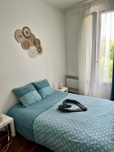 une chambre avec un lit avec une couette bleue dans l'établissement Manaca F2 - Le Raincy Centre Ville-Paris, à Le Raincy