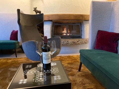 a room with a table with wine glasses and a fireplace at Hotel Schloss Berg in Berg am Starnberger See
