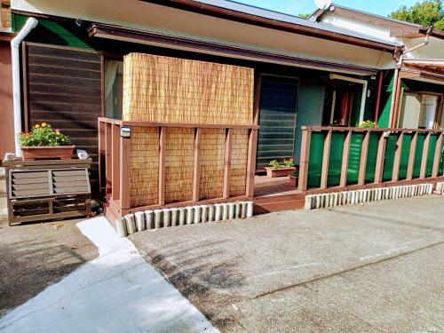 a house with a wooden gate and a porch at AJITO in Oshima