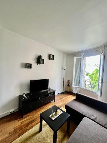 un salon avec un canapé et une table dans l'établissement Manaca F2 - Le Raincy Centre Ville-Paris, à Le Raincy