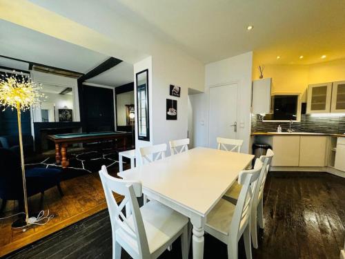 une cuisine et une salle à manger avec une table et des chaises blanches dans l'établissement Sainte-barbe T4, Billard à 2 pas du château fort, à Sedan