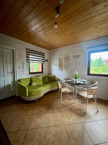 a living room with a green couch and a table at Ośrodek Daglezja in Kołczewo
