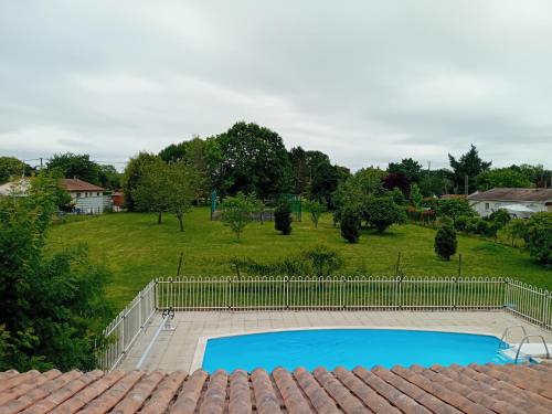 une piscine avec une clôture et une cour dans l'établissement La Coraillaise, à Saint-Aigulin