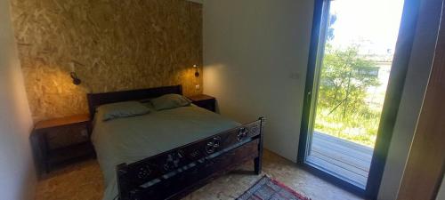 une chambre avec un lit et une grande fenêtre dans l'établissement Maison bord de mer, à La Tremblade