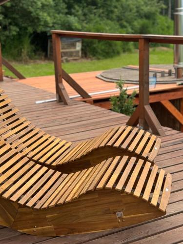 a wooden bench sitting on top of a wooden deck at Glamping Salaš in Mochtín