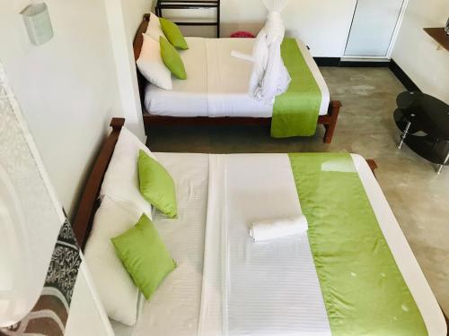 a room with two beds and a couch in it at Ella Jayamali Holiday Pavilion in Ella