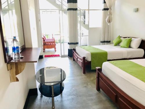 a hotel room with two beds and a window at Ella Jayamali Holiday Pavilion in Ella