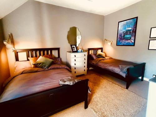 a bedroom with two beds and a mirror at Bryansford Cottage in Castlewellan