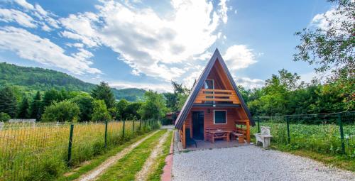 a small cabin in a field with a fence at Pyramid Energy House in Visoko