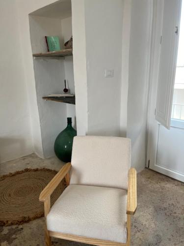 a white chair in a room with a green vase at L’Edicola Votiva in Casarano