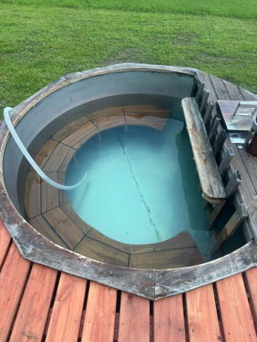 a circular pool on a wooden deck with a hose at Glamping Salaš in Mochtín