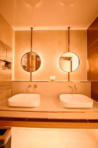 two sinks in a bathroom with two mirrors at Hanok Hotel DAAM Seoul in Seoul