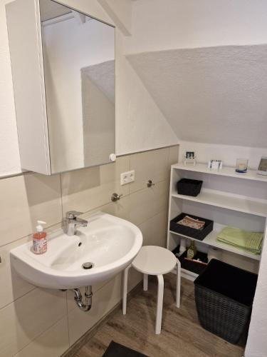 a bathroom with a sink and a mirror and a stool at Ferienhaus Heimes in Klotten