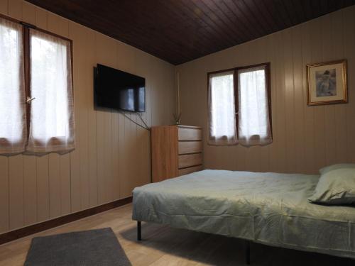 une chambre avec un lit et une télévision à écran plat dans l'établissement LA MAISON DU CAMINOL, à Monségur