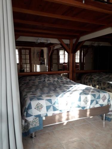 un lit dans une chambre avec un plafond en bois dans l'établissement T1BIS à 7 minutes à pied de la plage et du centre, à Villers-sur-Mer