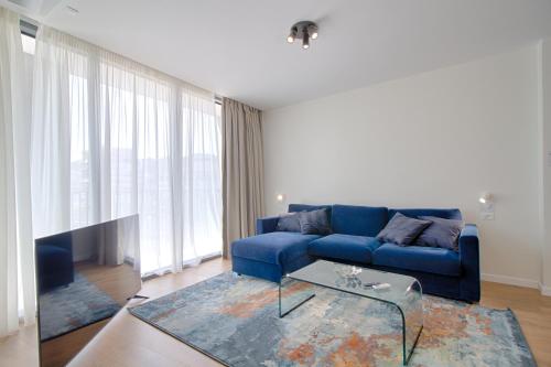 a living room with a blue couch and a table at The Rooms Serviced Apartments Tirana in Tirana