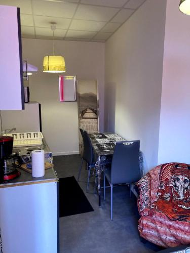 Cette chambre comprend une cuisine, une table et des chaises. dans l'établissement Studio 2em étage votre pèlerinage à Lourdes, à Lourdes