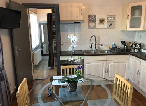 - une cuisine avec une table en verre et un évier dans l'établissement Bel Appartement 4 personnes bien placé, à Boulogne-sur-Mer