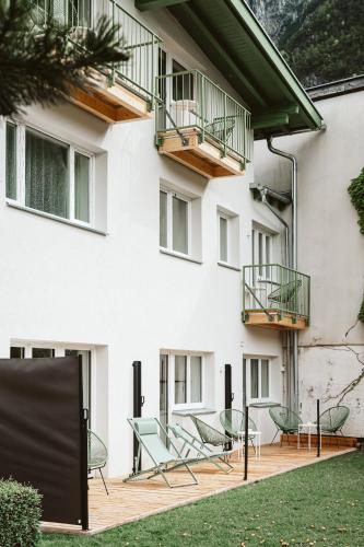 a patio in front of a building with chairs at Lebe' scharnitz in Scharnitz
