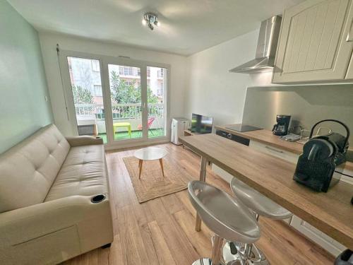 un salon avec un canapé, une table et des chaises dans l'établissement Appartement Cosy - Terrasse clim, à Nice