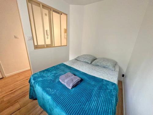 une chambre avec un lit avec une couverture bleue dans l'établissement Appartement Cosy - Terrasse clim, à Nice