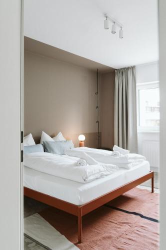 a large white bed in a room with a mirror at Lebe' scharnitz in Scharnitz
