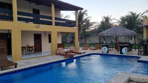 a swimming pool in front of a house at Casa Ferreira Cumbuco in Caucaia