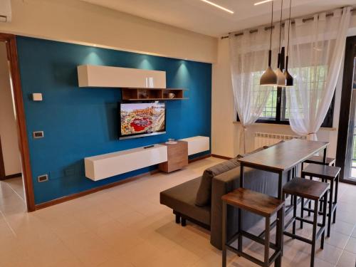 comedor con pared azul, mesa y sillas en Appartamento Divino Superior, en Altedo