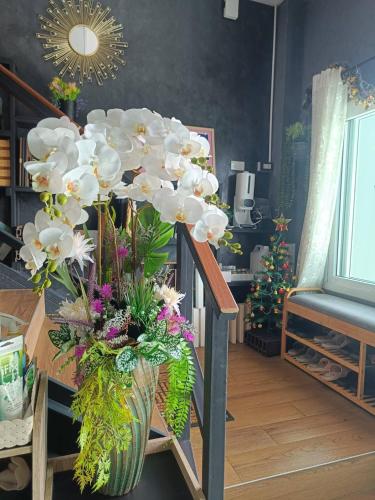 a vase filled with flowers sitting on a table at Merit Courtyard Suvarnabhumi House in Lat Krabang