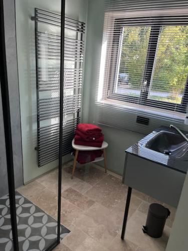 La salle de bains est pourvue d'un lavabo, d'une fenêtre et d'une table. dans l'établissement Le chalet, à Saint-Lubin-en-Vergonnois