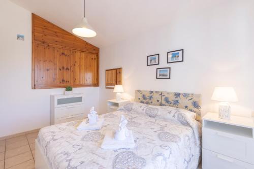 a bedroom with a bed with two dolls on it at Casa Calasetta sul porto in Calasetta