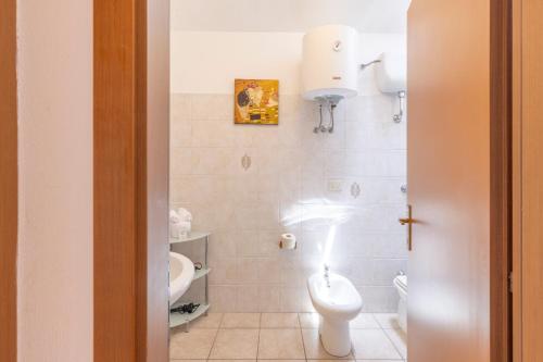 a white bathroom with a toilet and a sink at Casa Calasetta sul porto in Calasetta