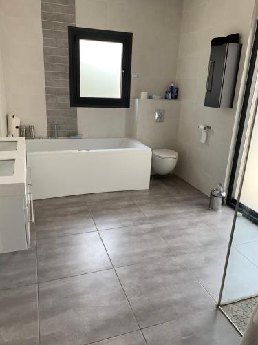 une salle de bain avec une baignoire, un lavabo et des toilettes dans l'établissement Villa climatisé contemporaine 8 personnes, à Jacou