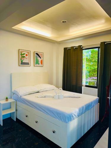 a white bed in a room with a window at Dolce Residencia in Tacloban