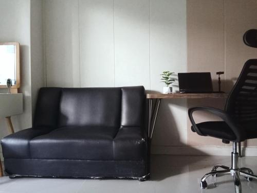 a black leather chair sitting next to a desk with a laptop at Morning cozy, airport 5-30 min in Pak Kret