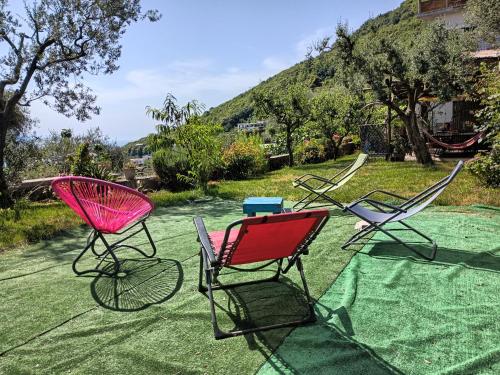 three chairs sitting on top of a green lawn at Amalfi Coast, Positano, Sorrento, Capri, Garden, Villa Carcara in Colli di Fontanelle