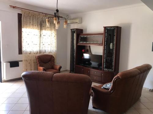 a living room with two chairs and a television at Kali Stalonia in Nikiti