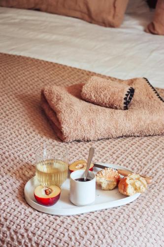 een dienblad donuts op een bed met een bord eten bij CASA ALENTI - Maison d'Hôtes in Beaumes-de-Venise