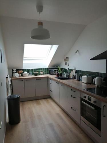 une grande cuisine avec une lucarne au plafond dans l'établissement T2 58M2, proche Orly et Disney, parking, ligne métro 8 à 5 minutes, à Créteil