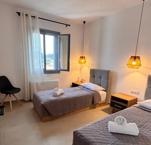 a hotel room with two beds and a window at Pyrra apartments in Skiros