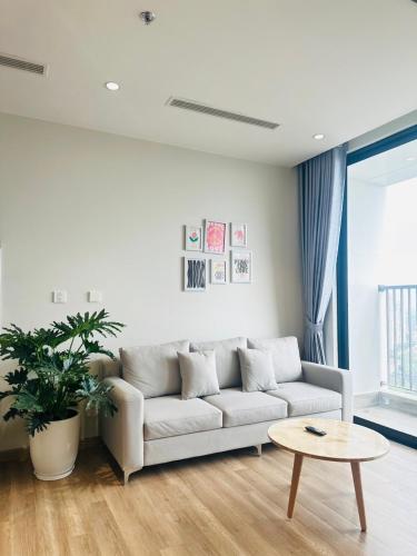 a white living room with a couch and a table at Nature Retreat- căn hộ nghỉ dưỡng khoáng nóng in HÆ°ng YÃªn