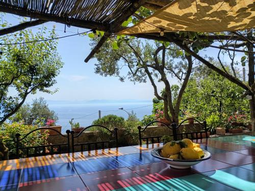 a table with a bowl of fruit on top of it at Amalfi Coast, Positano, Sorrento, Capri, Garden, Villa Carcara in Colli di Fontanelle