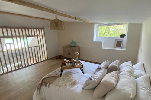 - un grand canapé blanc dans une chambre avec une table dans l'établissement La petite maison, à Falaise