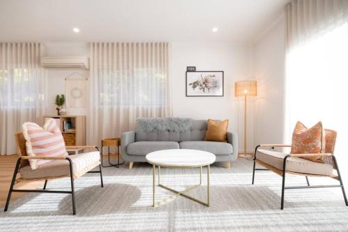 a living room with a couch and two chairs at Dovecote - Launceston Luxury in Inveresk