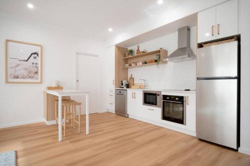 a kitchen with a white refrigerator and a table at Dovecote - Launceston Luxury in Inveresk