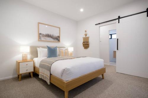 a bedroom with a large bed and a door to a hallway at Dovecote - Launceston Luxury in Inveresk