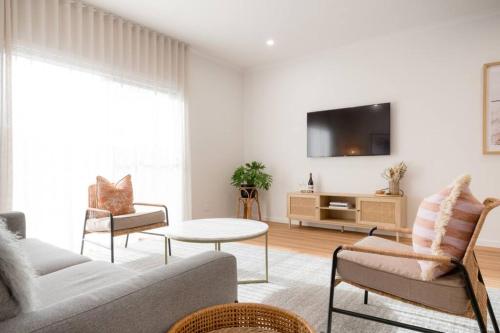 a living room with a couch and a table at Dovecote - Launceston Luxury in Inveresk